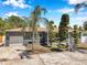 Charming home showcasing manicured landscaping, a gray exterior, and an attached garage at 936 Alcazar Way S, St Petersburg, FL 33705