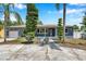 Charming single-story home featuring an inviting front porch, well-manicured lawn, and decorative landscaping at 936 Alcazar Way S, St Petersburg, FL 33705