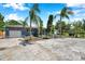 Well-maintained home with mature palm trees, a driveway, an attached garage and lush landscaping at 936 Alcazar Way S, St Petersburg, FL 33705