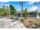 Single-story home with eye-catching landscaping, a front porch, and an attached garage at 936 Alcazar Way S, St Petersburg, FL 33705