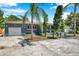 Quaint single-story home with a garage, well-maintained front yard, unique landscaping, and mature trees at 936 Alcazar Way S, St Petersburg, FL 33705