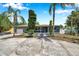 Inviting single-story home with a driveway, landscaping, a front porch, and an attached garage at 936 Alcazar Way S, St Petersburg, FL 33705