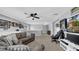 Spacious bonus room with a gray couch, TV, ceiling fan, and sports memorabilia at 10505 Boyette Creek Blvd, Riverview, FL 33569