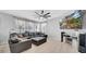 Bright living room showcases a cozy leather sectional, a modern ceiling fan, and a large wall-mounted television at 10505 Boyette Creek Blvd, Riverview, FL 33569
