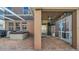Covered patio with a hot tub, brick flooring, and outdoor television, providing a comfortable space for relaxation and entertainment at 10505 Boyette Creek Blvd, Riverview, FL 33569