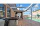 Enclosed patio featuring a hot tub, brick flooring, and view of the pool, perfect for outdoor relaxation and enjoyment at 10505 Boyette Creek Blvd, Riverview, FL 33569