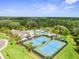 Aerial view of the community pool and tennis courts surrounded by lush landscaping is a Gathering oasis at 10901 Sundrift Dr, Tampa, FL 33647