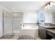 Bright bathroom featuring double vanity with granite counters, glass enclosed shower and soaking tub at 10901 Sundrift Dr, Tampa, FL 33647
