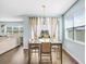 Sunlit dining area with contemporary table set, large windows with curtains, and a view to the living room at 10901 Sundrift Dr, Tampa, FL 33647