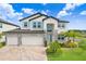 Charming two-story home featuring a stone accent, three-car garage, manicured lawn, and inviting light blue front door at 10901 Sundrift Dr, Tampa, FL 33647