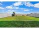 Spacious backyard featuring a playground, a fire pit, and a white vinyl fence at 11079 Linden Depot Rd, San Antonio, FL 33576
