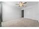 Bright bedroom featuring neutral carpet, ceiling fan, and a double-door closet for ample storage at 11079 Linden Depot Rd, San Antonio, FL 33576