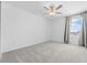 Bright bedroom features plush carpeting, a large window, and neutral color scheme at 11079 Linden Depot Rd, San Antonio, FL 33576