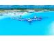Expansive community pool and recreational area with inflatable water park and sandy beach under sunny skies at 11079 Linden Depot Rd, San Antonio, FL 33576