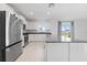 Bright kitchen featuring white cabinets, stainless steel appliances, and a granite countertop island at 11079 Linden Depot Rd, San Antonio, FL 33576