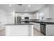 Bright kitchen featuring white cabinets, stainless steel appliances, and a granite countertop island at 11079 Linden Depot Rd, San Antonio, FL 33576