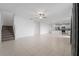 Open-concept living space with stairs, tile flooring, neutral paint, and a view into the modern kitchen at 11079 Linden Depot Rd, San Antonio, FL 33576