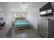 Primary bedroom showcasing a tufted headboard, ceiling fan, and an entertainment center at 11104 Hackney Dr, Riverview, FL 33578