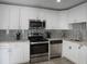 Modern kitchen featuring stainless steel appliances, white cabinets, and stylish backsplash at 11104 Hackney Dr, Riverview, FL 33578