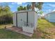 Outdoor shed with double doors and adjacent planter box, offering practical storage and a touch of greenery at 11104 Hackney Dr, Riverview, FL 33578