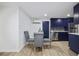 Dining area with a view into the kitchen with stainless steel appliances and blue cabinets at 11747 104Th N St, Largo, FL 33773
