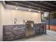 Stylish outdoor kitchen featuring a stainless steel grill, sink, mini fridge and modern lighting fixtures at 11747 104Th N St, Largo, FL 33773