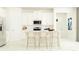 Modern white kitchen featuring stainless steel appliances, center island, and bar stool seating at 11841 Sparkling Topaz Cv, Parrish, FL 34219
