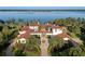 Stunning lakefront estate boasts lush landscaping, red tile roof, and circular driveway at 11865 Fort King Hwy, Thonotosassa, FL 33592
