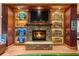 Cozy stone fireplace with built-in display shelves featuring sports memorabilia and a mounted TV at 11865 Fort King Hwy, Thonotosassa, FL 33592