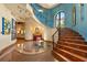 Grand foyer features a curved staircase, unique wall art, and a retro terrazzo floor design at 11865 Fort King Hwy, Thonotosassa, FL 33592