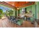 Outdoor kitchen with bar seating, stainless steel grill, and lush tropical surroundings at 11865 Fort King Hwy, Thonotosassa, FL 33592