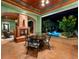 Relaxing outdoor living area with fireplace and dining table overlooking pool with water feature at 11865 Fort King Hwy, Thonotosassa, FL 33592