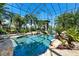 Stunning pool area with rock features, lush landscaping, and a screened enclosure at 11865 Fort King Hwy, Thonotosassa, FL 33592