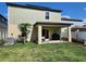 Back of house with a covered patio, green lawn, and landscaping at 12537 Timber Moss Ln, Riverview, FL 33579