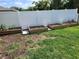 Backyard featuring several raised garden beds with vegetable plants along a white vinyl fence at 12537 Timber Moss Ln, Riverview, FL 33579
