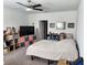 Bedroom with neutral carpet, a ceiling fan, a TV, and decorative shelving for storage at 12537 Timber Moss Ln, Riverview, FL 33579