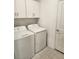 Functional laundry room equipped with a washer, dryer, and white cabinets for storage, plus easy access to an exterior door at 12537 Timber Moss Ln, Riverview, FL 33579