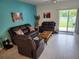 Inviting living room with tile floors, comfortable leather furniture, and a sliding glass door to the patio at 12537 Timber Moss Ln, Riverview, FL 33579