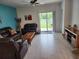 Inviting living room with tile floors, comfortable leather furniture, and a sliding glass door to the patio at 12537 Timber Moss Ln, Riverview, FL 33579