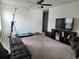 Cozy living room featuring carpet flooring, ceiling fan, and a large TV with entertainment center at 12537 Timber Moss Ln, Riverview, FL 33579