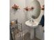 Powder room includes a pedestal sink, a round mirror, and decorative wall hangings at 12537 Timber Moss Ln, Riverview, FL 33579
