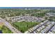 Bird's-eye view displays a community layout with uniform housing, ponds, greenery, and surrounding roads at 1432 Gopher Loop, Tarpon Springs, FL 34689