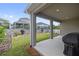 Covered back porch overlooking a well-maintained backyard, perfect for outdoor entertaining and relaxation at 1432 Gopher Loop, Tarpon Springs, FL 34689