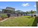 Spacious backyard features a black fence, retaining wall with garden, and lush green grass at 1432 Gopher Loop, Tarpon Springs, FL 34689