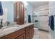 Modern bathroom featuring double sinks with granite countertops and a glass-enclosed shower with blue accents at 1432 Gopher Loop, Tarpon Springs, FL 34689