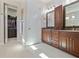 A bathroom with double vanities and granite countertop has an adjacent walk-in closet at 1432 Gopher Loop, Tarpon Springs, FL 34689
