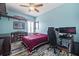 Cozy bedroom featuring hardwood floors, a ceiling fan, and a custom bookshelf for storing games and books at 1432 Gopher Loop, Tarpon Springs, FL 34689