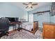Tranquil bedroom with light blue walls, wooden floors, a ceiling fan, and plenty of natural light at 1432 Gopher Loop, Tarpon Springs, FL 34689