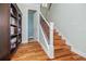 Bright entryway showcasing hardwood floors, a staircase with wood treads, and a convenient half-bathroom at 1432 Gopher Loop, Tarpon Springs, FL 34689
