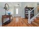 Charming entryway with hardwood floors, staircase, elegant furnishings, and a bookcase for added character at 1432 Gopher Loop, Tarpon Springs, FL 34689